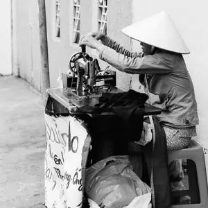 Woman working with sewing machine on sidewalk