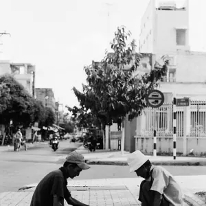 歩道でベトナム将棋を指す男たち