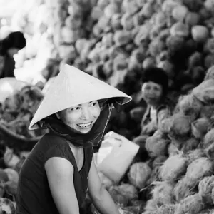Woman smiling beside coconuts