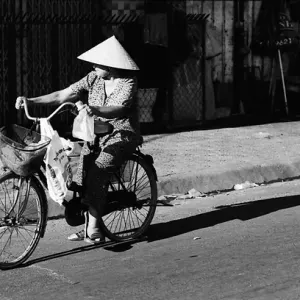 Women with conical hat riding bicycle