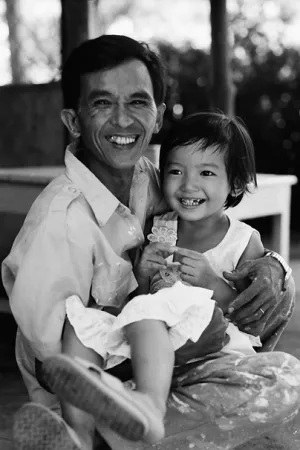 Smiling father holding smiling daughter