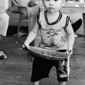 Little boy holding cooking vessel