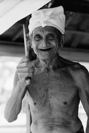 Smiling old man holding knife
