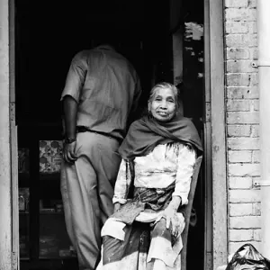 Older woman sitting in front of door