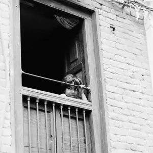 Girl peeking through upstairs window