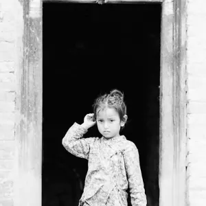 Little girl standing in front of door