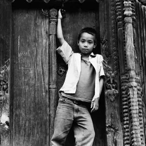 Boy striking pose in front of wooden door