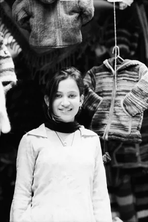 Young woman standing in front of sweaters