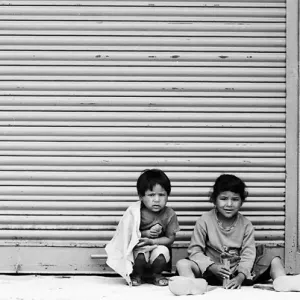Kids sitting in front of shutter