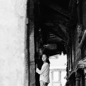 Girl looking back in corridor of temple