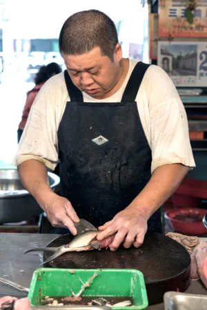 Fishmonger cutting fish
