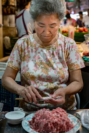 Woman wrapping minced flesh
