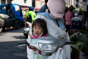 Girl on motorbike with mother