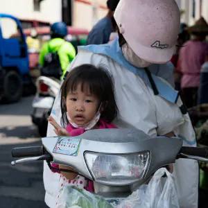 Girl on motorbike with mother