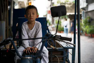 三輪バイクの座席に乗っていた幼い男の子