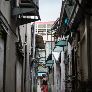 路地をフラフラと歩く女性