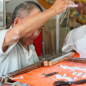 Man stitching a banner