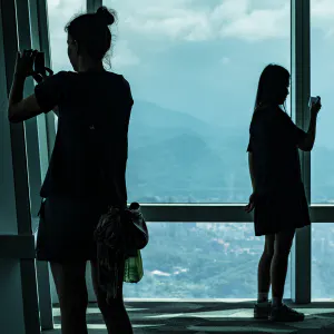 Two silhouetted women taking photos