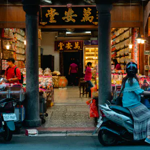 Young woman on motorbike stopping in storefront