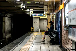 Woman sitting on bench on platform