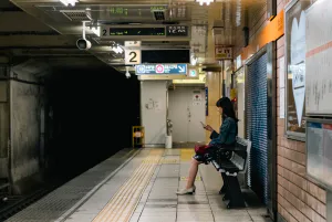 Woman sitting on bench on platform