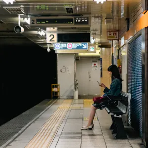 Woman sitting on bench on platform