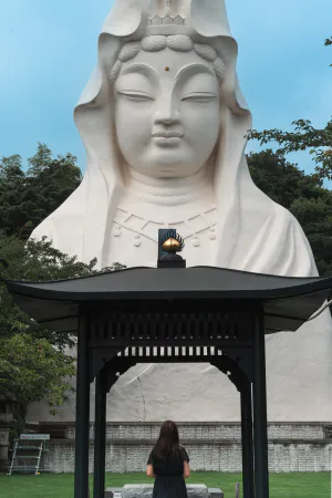 Woman praying in front of Guanyin