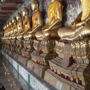 Man sleeping in front of Buddha images