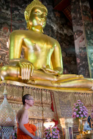 Buddhist monk in front of Buddha image