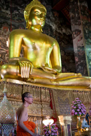 Buddhist monk in front of Buddha image