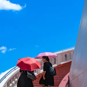 Women climbing red stairway in Wat Saket