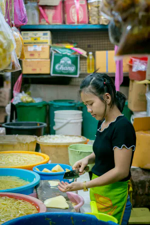 クーロントゥーイ市場で野菜をカットする若い女性