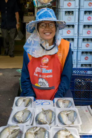 パック詰めの魚を売る女