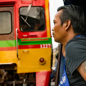 Train and man in Mae Klong market
