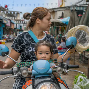 Little girl riding motorbike with mother