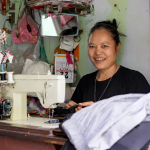 Woman working with power-operated sewing machine