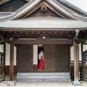 Shinto priestess getting into a building