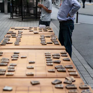 Man watching another man playing Shogi