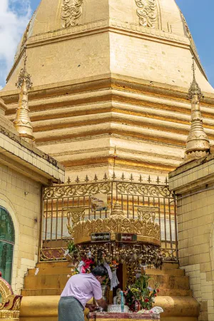 Man making offering to altar in Sule Pagoda