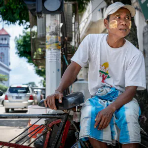 Pedicab driver waiting for customers in a street corner