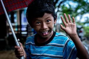 Boy smiling while holding umbrella