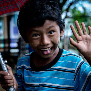 Boy smiling while holding umbrella