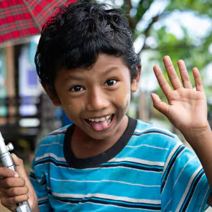 Boy smiling while holding umbrella