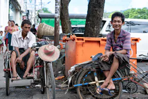 Rickshaw men sat on saddle of vehicle