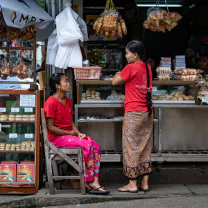 Two women chatting in front of counter