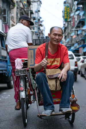 Man thumbing up on seat of pedicab