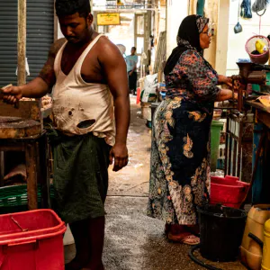 Two persons working back to back in butcher