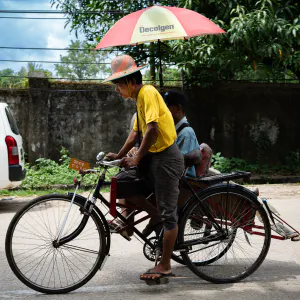 Pedicab with umbrella passing by