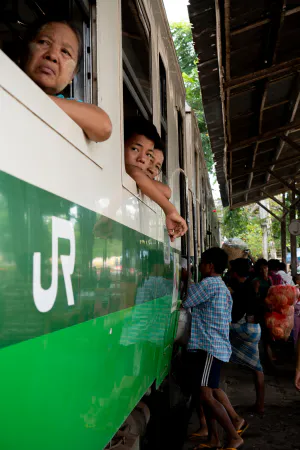 ダニンゴン駅に停まっている列車の窓から顔を出す乗客