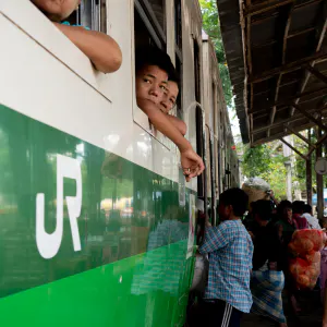 ダニンゴン駅に停まっている列車の窓から顔を出す乗客